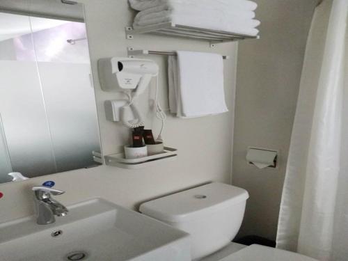 a bathroom with a toilet and a sink and a mirror at JUN Hotels Hebei Hengshui Taocheng District Heping West Road in Hengshui