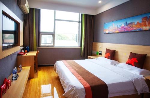 um quarto com uma cama grande e uma janela grande em JUN Hotels Hebei Hengshui Shenzhou Bus Station em Hengshui