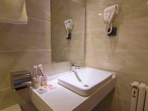 a bathroom with a white sink and a mirror at Thank Inn Chain Hotel Yinchuan Xingqing District Gulou Pedestrian Street in Yinchuan