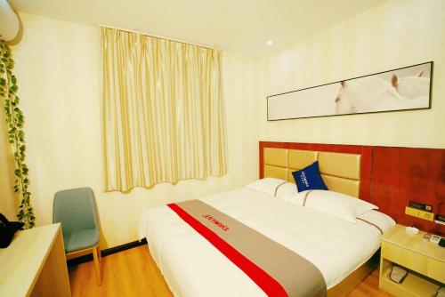 Un pat sau paturi într-o cameră la JUN Hotels Gansu Jiayuguan Jingtie District Guanghui Community