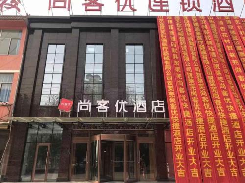 a building with writing on the front of it at Thank Inn Chain Hotel Shandong Laiwu Laicheng District Changshou North Road People's Hospital in Laiwu