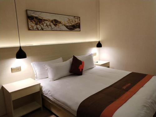 1 dormitorio con 1 cama blanca grande y 2 lámparas en JUN Hotels Gansu Lanzhou Chengguan DIstrict Lanzhou University en Lanzhou
