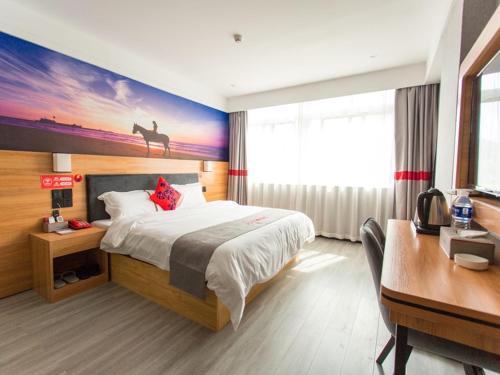 a hotel room with a large bed and a desk and a desk at JUN Hotels Hubei Xianning Tongshan County Jiugong Avenue in Xianning