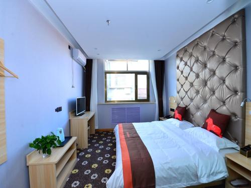 a bedroom with a large bed in a blue room at JUN Hotels Shanxi Changzhi Xiangyuan Taihang Road JuranZhijia in Changzhi