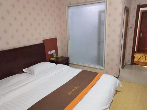 a bedroom with a large bed and a window at JUN Hotels Hebei Baoding Rongheng Jintai West Road in Baoding