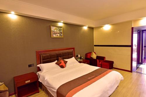 1 dormitorio con 1 cama grande y 1 silla en JUN Hotels Sichuan Xhengdu Pidu University City en Chengdú