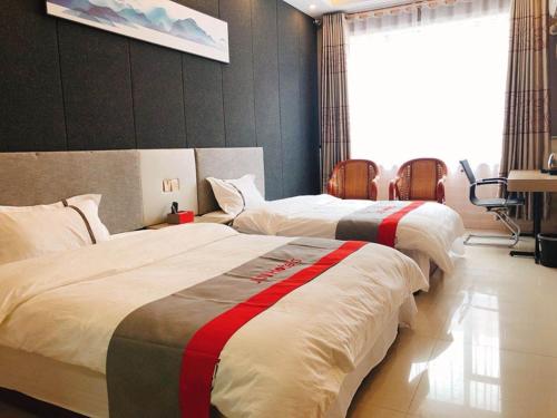 two beds in a hotel room with at JUN Hotels Shandong Binzhou Boxing County Bus Station in Binzhou