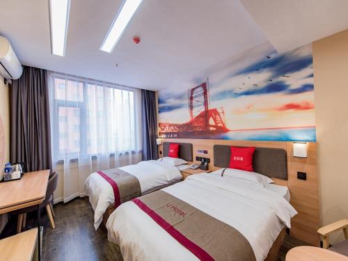 una habitación de hotel con 2 camas y una pintura de un puente en Thank Inn Chain Hotel Luoyang Jianxi District Jianshe Road, en Luoyang