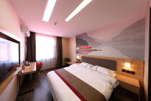 Thank Inn Plus Hotel Qingdao Jiaozhou Jiaoping Road high-speed intersection في تشينغداو: غرفة نوم بسرير ودهان على الحائط