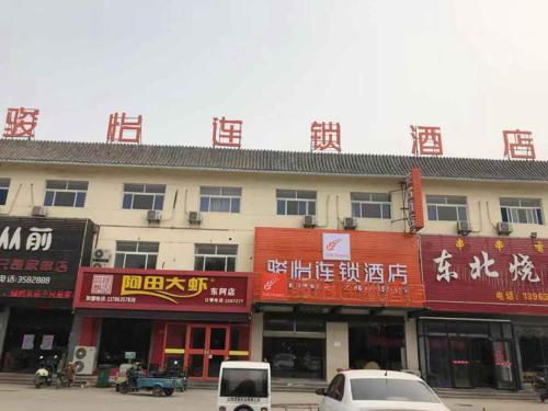 a building with signs on the side of it at JUN Hotels Shandong Liaocheng Dong'a County Bus Station Store in Liaocheng