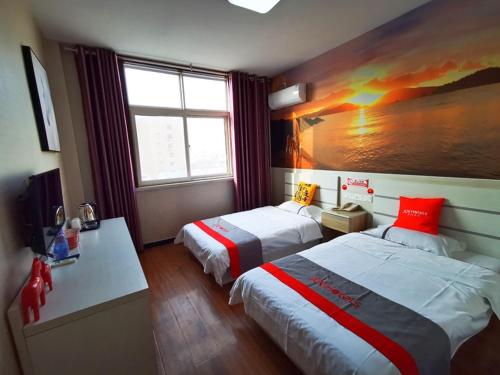 una habitación de hotel con 2 camas y un cuadro en la pared en JUN Hotels Hebei Hengshui Taocheng District Renmin Road Changming Avenue, en Hengshui