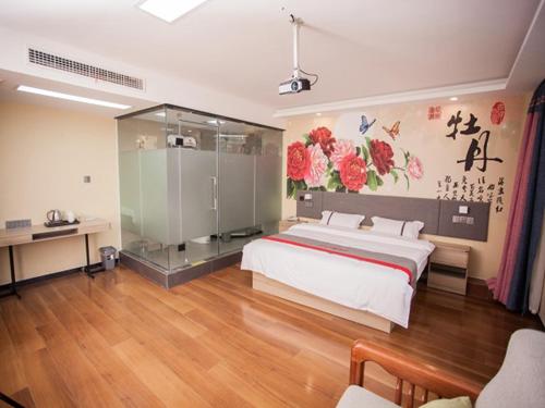 um quarto com uma cama grande e uma cabina de duche em vidro em JUN Hotels Shandong Heze Development Zone Shanghai Road em Xinji