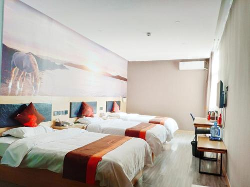 a hotel room with three beds and a painting of a giraffe at JUN Hotels Hebei Xingtai Qinghe County Bohai Road in Huangjinzhuang
