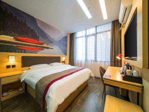 Thank Inn Plus Hotel Guizhou Zunyi Old Railway Station في زونيي: غرفة فندقية فيها سرير ومكتب وتلفزيون