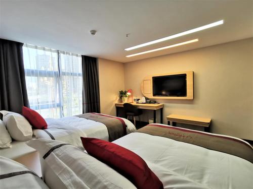 um quarto de hotel com duas camas e uma televisão de ecrã plano em Thank Inn Chain Hotel Guangan Huaying Phoenix City em Shuang-ho