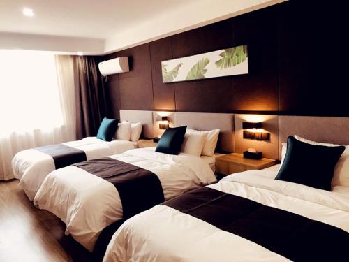 un grupo de 4 camas en una habitación de hotel en Up And In Kashgar Shache County Buxing Street, en Shache