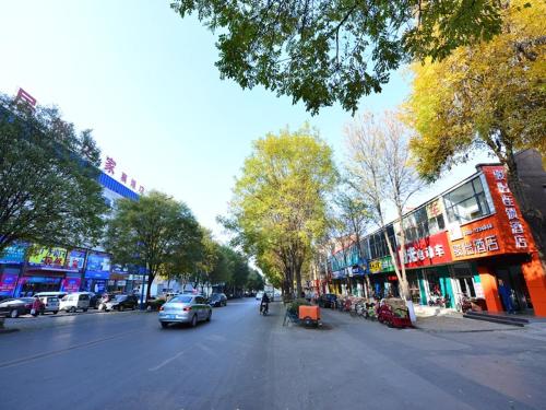 a city street with cars driving down the street at JUN Hotels Shanxi Changzhi Xiangyuan Taihang Road JuranZhijia in Changzhi