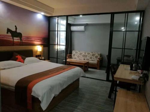 a hotel room with a bed and a couch at JUN Hotels Zhejiang Jiaxing Haiyan Qiyuan North Road in Jiaxing