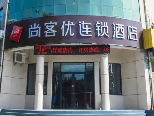 un edificio con un cartel en la parte delantera en Thank Inn Chain Hotel Hebei Handan Wu'an City Bus Station, en Handan