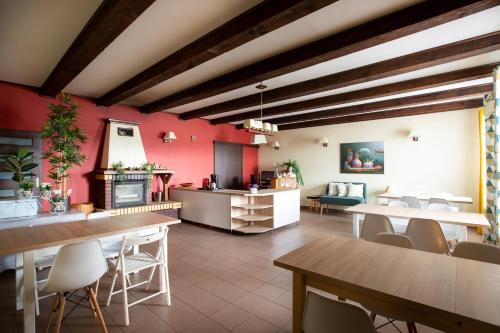 a restaurant with tables and chairs and a red wall at Pensjonat pod Kasztanem in Ełk