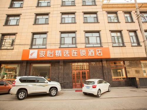 zwei vor einem Gebäude geparkt in der Unterkunft JUN Hotels Hebei Shijiazhuang Wuji County Zhengyi Street Store in Shijiazhuang