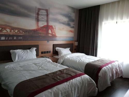 twee bedden in een hotelkamer met een schilderij aan de muur bij Thank Inn Chain Hotel Jiangsu Suzhou Wuzhong Hongzhuang Subway Station in Suzhou