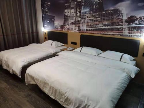 two beds in a hotel room with a view of a city at Thank Inn Chain Hotel Luoyang Mengjin County Yellow River Avenue Bus Station in Luoyang