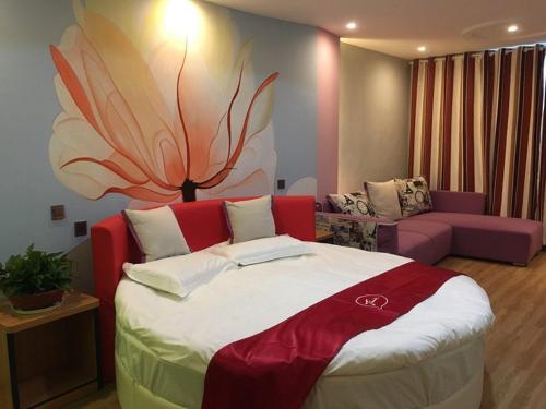 sypialnia z dużym łóżkiem z dużym kwiatem na ścianie w obiekcie Thank Inn Chain Hotel Xuzhou Quanshan District Yunlong Lake w mieście Xuzhou