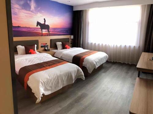 a hotel room with two beds and a horse painting on the wall at JUN Hotels Shandong Liaocheng Dong'a County Bus Station Store in Liaocheng