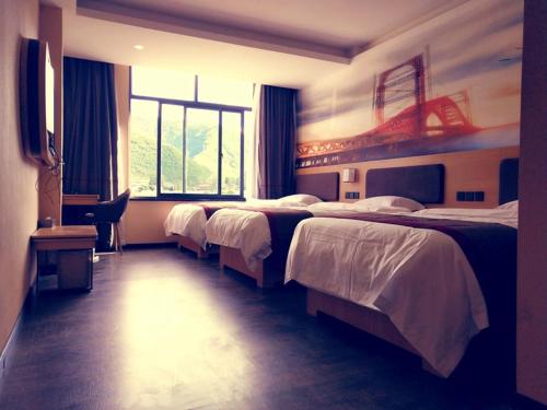 GarzeにあるThank Inn Chain Hotel Ganzi Kangding City Xinduqiaoのベッド3台と窓が備わるホテルルームです。