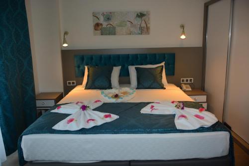 a bedroom with a bed with two dresses on it at THe NORDİC HOTEL in Kemer