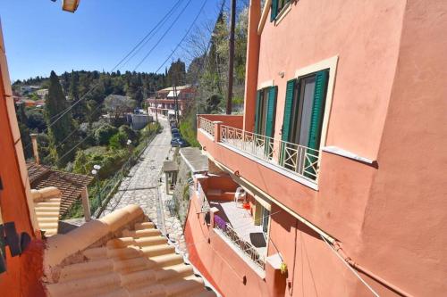 an orange building with a balcony and a street at Traditional House with Amazing View in Chlomós