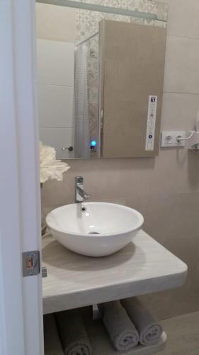a bathroom with a white sink and a mirror at Apartamento Pimienta in Tarifa