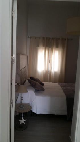 a bedroom with a white bed and a window at Apartamento Pimienta in Tarifa