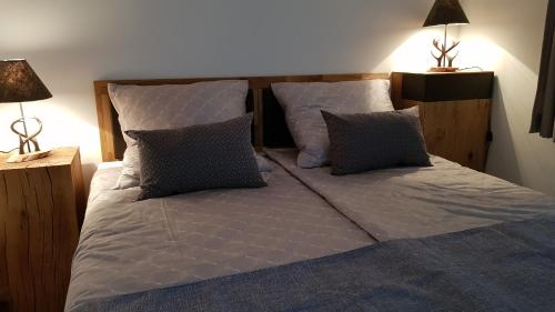 a large bed with two pillows and two lamps at Gästehaus Sabine in Voitsberg