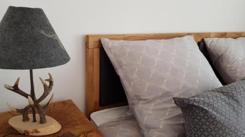 a lamp on a table next to a bed at Gästehaus Sabine in Voitsberg