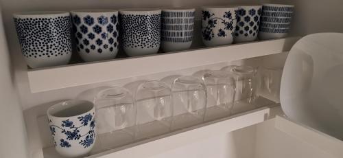 a shelf with many glass cups on it at Sehr schöne Ferienwohnung im historischen Borken-Gemen in Borken