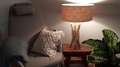 a lamp on a table next to a couch with a pillow at Gästehaus Sabine in Voitsberg