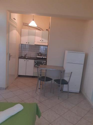 a kitchen with a table and chairs and a refrigerator at Eliza Apartments in Rethymno Town