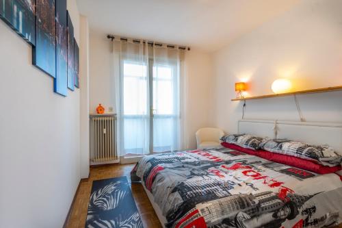 ein Schlafzimmer mit einem großen Bett und einem Fenster in der Unterkunft ZIA DINA APARTMENT in Pasian di Prato