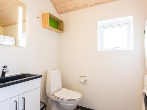 a bathroom with a toilet and a sink and a window at 10 person holiday home in Nørre Nebel in Nørre Nebel