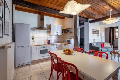 une cuisine et une salle à manger avec une table et des chaises dans l'établissement La Cour St-Fulrad - Appartements, à Saint-Hippolyte