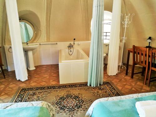 a bathroom with a tub and a toilet and a sink at Safari Guesthouse in Vryburg
