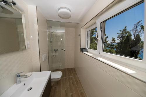 新維諾多爾斯基的住宿－Mitan Accommodation，浴室设有窗户、水槽和卫生间。