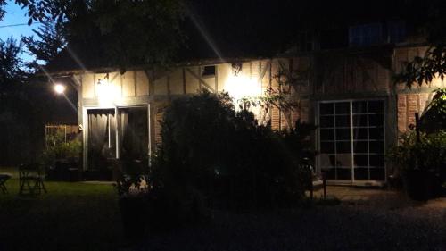 a house with lights on the side of it at night at L'Escapade in Foulbec