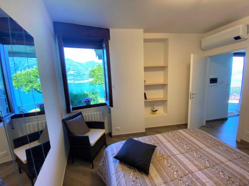 Un dormitorio con una cama y una silla y una ventana. en Il Bellavista, en Lezzeno