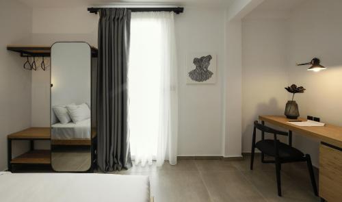 a bedroom with a bed and a desk and a window at Pillow urban stay in Thessaloniki