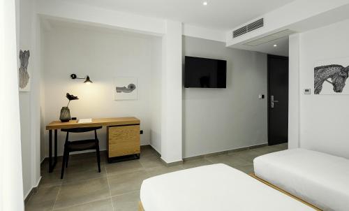 a bedroom with a desk and a bed and a table at Pillow urban stay in Thessaloniki