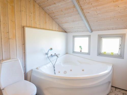 a bathroom with a white tub and a toilet at 6 person holiday home in Hvide Sande in Havrvig