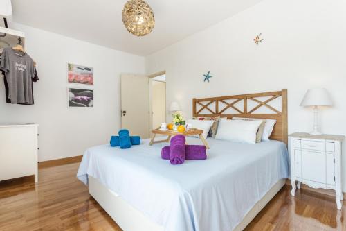 Un dormitorio con una cama blanca con almohadas moradas. en Magic Theatre Faro Center, en Faro